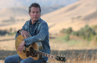 Man sitting rock guitar mountain - a sky free wallpaper for desktop