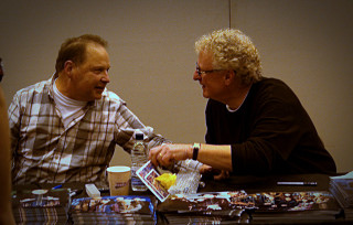 Two men sitting table food - a magazine free wallpaper