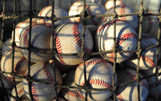 Baseballs in net pile on - free sports wallpaper
