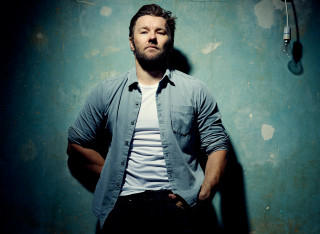 Man standing wall clock hands - his hands in his pockets free wallpaper