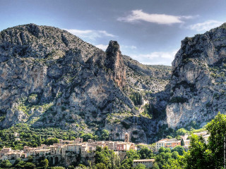 Mountain village nestled cloudy sky - a few tree below free wallpaper