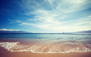Beach waves blue sky clouds - a boat in the distance free wallpaper