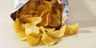 Chips bag and pile on - top of a table free wallpaper for desktop