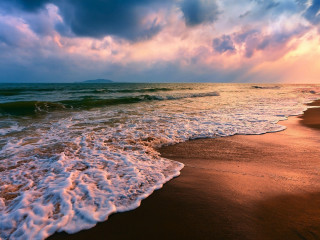 Beach sunset waves clouds mountain - a sunset in the background free wallpaper for desktop