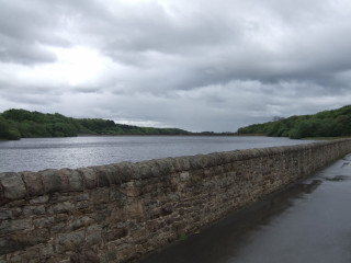 Stone wall water cloudy sky - a body of water under a cloudy sky free wallpaper