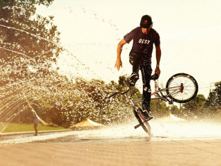 Man bike trick water wheel - his foot free wallpaper