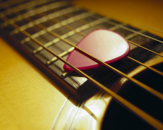 Guitar pick on guitar strings - focus free wallpaper for desktop