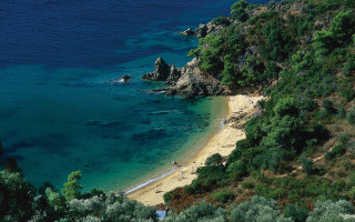 Beach rocky cliff water boat - a sandy shore free wallpaper
