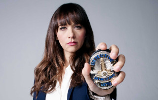 Woman holding clock serious look - her face and shoulder free wallpaper