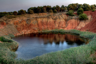 Small lake cliff grass hillside - free landscape wallpaper