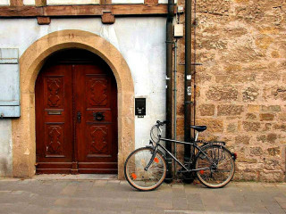 Bicycle parked building red door - a bicycle free wallpaper