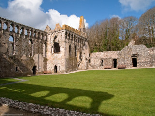 Large stone building green lawn - a shadow of a person free wallpaper