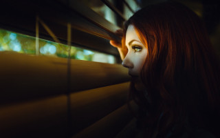 Woman looking out window blinds - blind free wallpaper