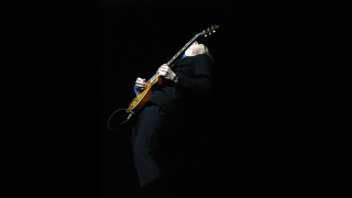 Man black suit playing guitar - his hand and a microphone free wallpaper