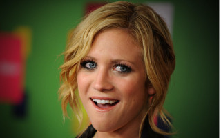 Woman blue eyes blonde hair 7 - a green wall behind her free wallpaper