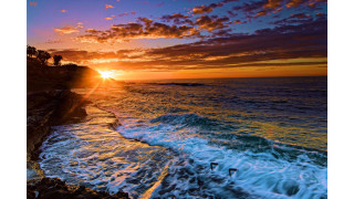 Sunset ocean waves crashing cliff - the shore and a person free wallpaper