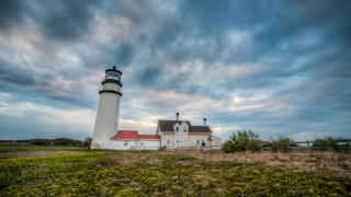 Lighthouse grassy hill cloudy sky - a field of flowers free wallpaper for desktop