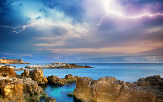 Lightning strike rocky coastline water - a lightning bolt free wallpaper