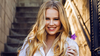 Woman holding purple flower smiling - amalia lindegren free wallpaper for desktop
