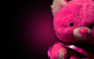 Pink teddy bear ribbon bow 4 - against a black background free wallpaper
