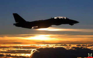 Jet flying cloudy sunset sky - a few cloud below free wallpaper