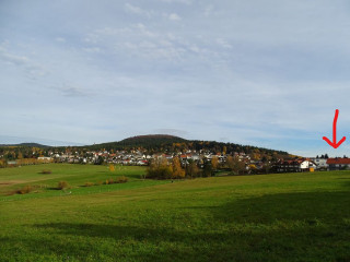 Green field red arrow town - a hill in the distance free wallpaper