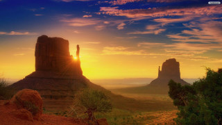 Sunset desert rock formation distant - a rock formation in the foreground free wallpaper