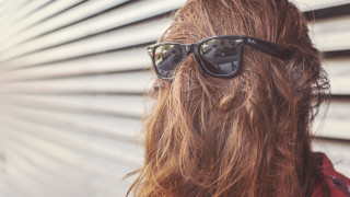 Woman long hair sunglasses looking - a white wall behind her free wallpaper