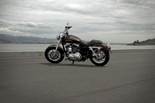Motorcycle parked ocean mountains cloudy - a motorcycle free wallpaper