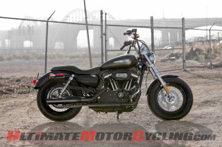 Motorcycle parked dirt lot fence - a bridge in the background free wallpaper