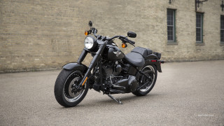 Motorcycle parked brick building wall - matte finish free wallpaper