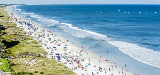 Crowded beach people walking sand - free beach wallpaper