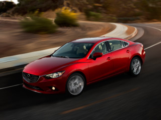 Red car driving road forest 2 - a hill in the background free wallpaper