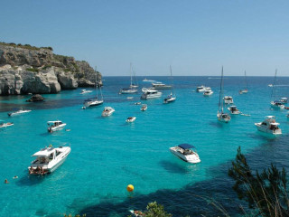 Boats cliff beach ocean sunburst - a blue water free wallpaper