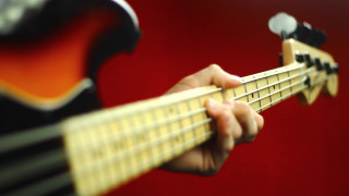 Person playing guitar red background - a red wall behind them free wallpaper
