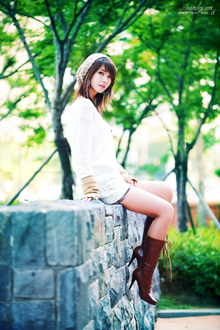 Woman sitting stone wall hat - a tilt shift photo free wallpaper for mobile