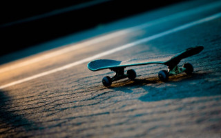 Skateboard laying ground wheels side - a blurry background free wallpaper