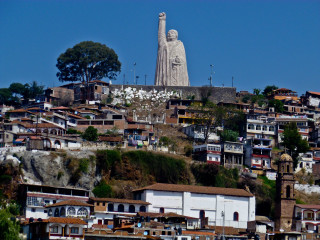 Large statue person hill buildings - top of a hill free wallpaper