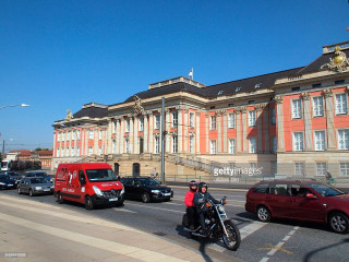 Man motorcycle street building red - perfect symmetry free wallpaper