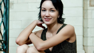 Woman sitting step hand chin - a brick wall behind her free wallpaper