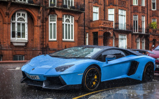 Blue sports car wet street - a brick building free wallpaper