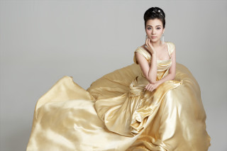 Woman golden dress posing hand - her cheek free wallpaper