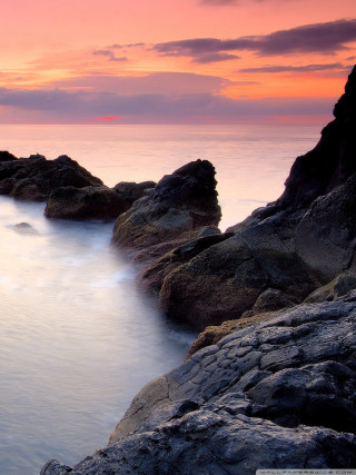Rocky shore sunset pink sky 2 - a pink sky in the background free wallpaper for mobile