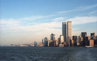 Large body of water city - a city in the background and a boat free wallpaper