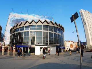 Large building poster people walking - viennese actionism free wallpaper