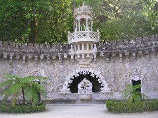 White building clock tower statue - a palm tree in the background free wallpaper