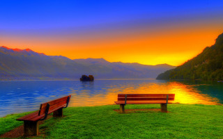 Bench lush green field lake - a boat in the distance free wallpaper