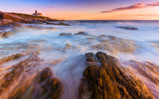 Lighthouse rocky shore water pink - a pink sky in the background free wallpaper