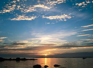 Sunset water rocks clouds sky 2 - a sunset over a body of water free wallpaper