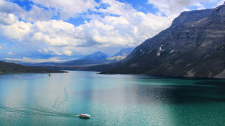 Boat floating mountains cloudy sky - a large body of water free wallpaper